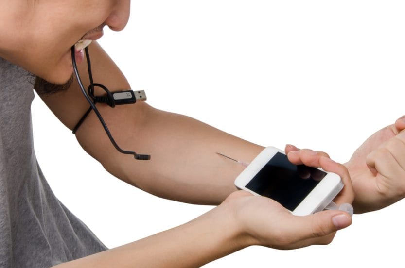 Homme s'injectant son smartphone tel un accro à l'heroïne